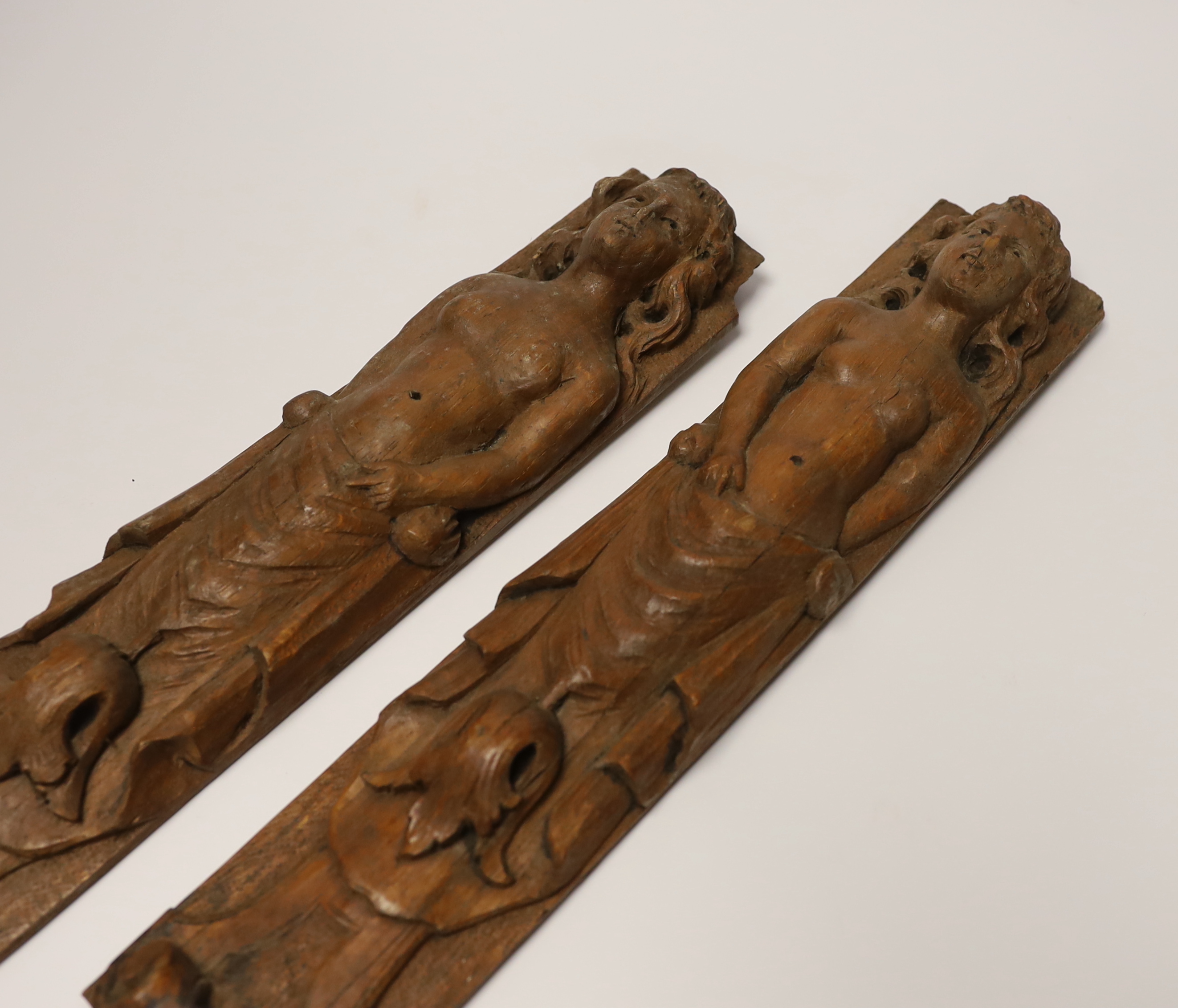 A pair of 17th century carved wood terminal figures, 39cm high